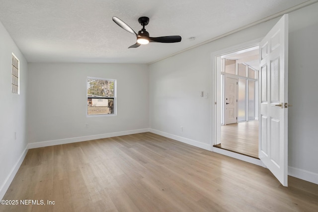 spare room with ceiling fan, light hardwood / wood-style flooring, and a textured ceiling