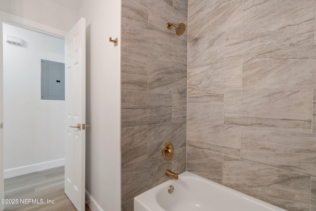 bathroom featuring hardwood / wood-style flooring, tiled shower / bath, and electric panel