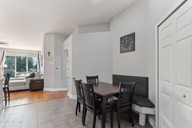 tiled dining room with a textured ceiling