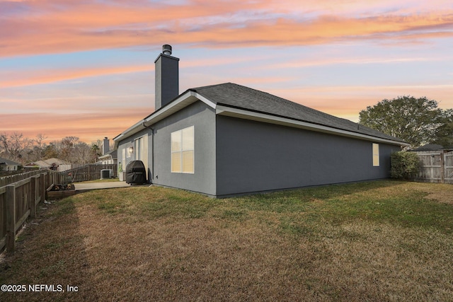 property exterior at dusk with a yard