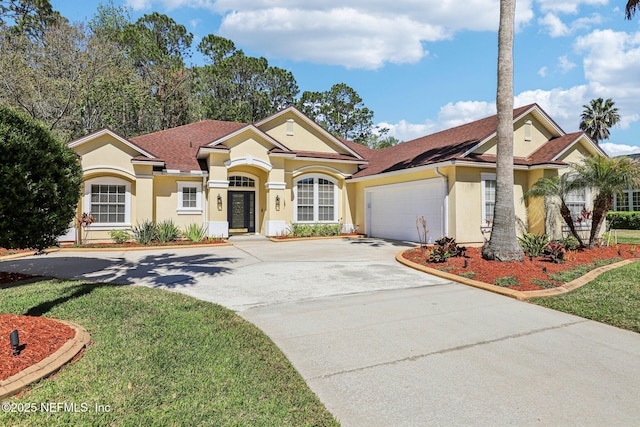 mediterranean / spanish-style house with a shingled roof, a front lawn, concrete driveway, stucco siding, and a garage