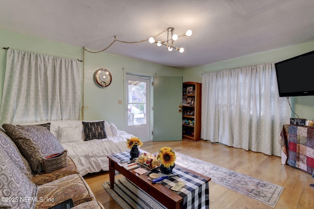 living room featuring a notable chandelier and light wood-type flooring