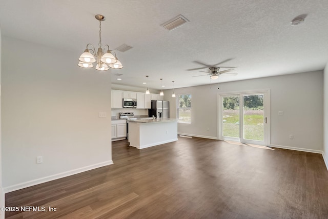 kitchen with dark wood-type flooring, white cabinetry, a kitchen island, pendant lighting, and stainless steel appliances