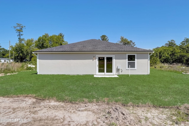 rear view of house featuring a lawn