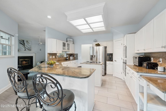 744 Cherry Grove Rd, Orange Park, FL 32073 - kitchen featuring a kitchen breakfast bar, kitchen peninsula, and white cabinets