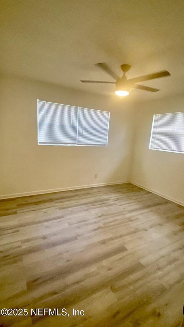 spare room with ceiling fan, a healthy amount of sunlight, and light wood-type flooring