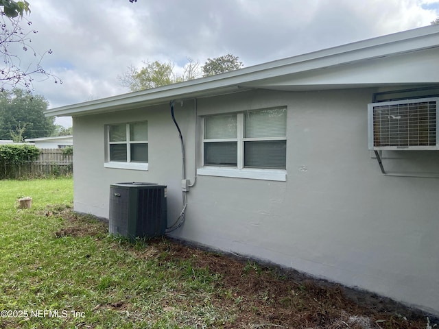 view of side of property with central AC and a lawn