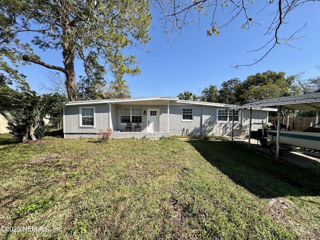 view of front of house featuring a carport, a front yard, and brick siding