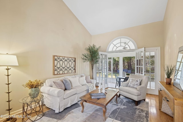 living room with hardwood / wood-style floors and high vaulted ceiling