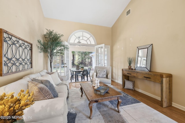 living room with high vaulted ceiling and hardwood / wood-style floors