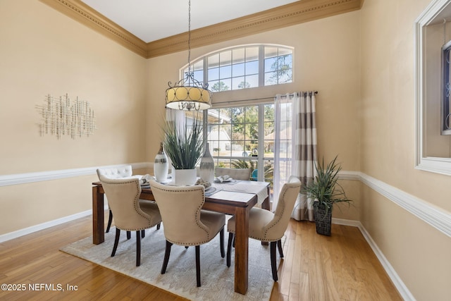 dining area featuring crown molding and light hardwood / wood-style flooring