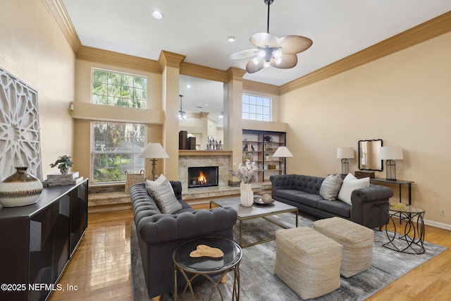 living room with hardwood / wood-style flooring, crown molding, a high ceiling, and ceiling fan