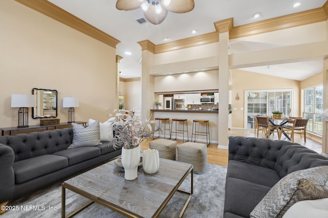 living room with ornamental molding, lofted ceiling, ceiling fan, and light hardwood / wood-style flooring