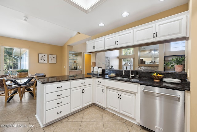 kitchen featuring white cabinetry, dishwasher, sink, dark stone countertops, and kitchen peninsula