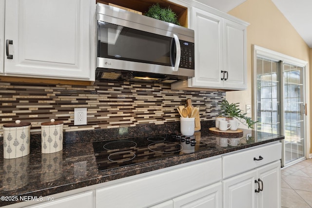 kitchen featuring tasteful backsplash, black electric stovetop, and white cabinets