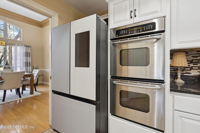 kitchen with white cabinetry, double oven, tasteful backsplash, and refrigerator