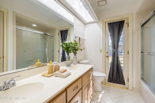 full bathroom featuring tile patterned floors, vanity, toilet, and enclosed tub / shower combo