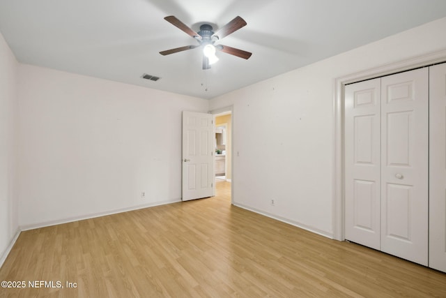 unfurnished bedroom with light hardwood / wood-style floors, a closet, and ceiling fan