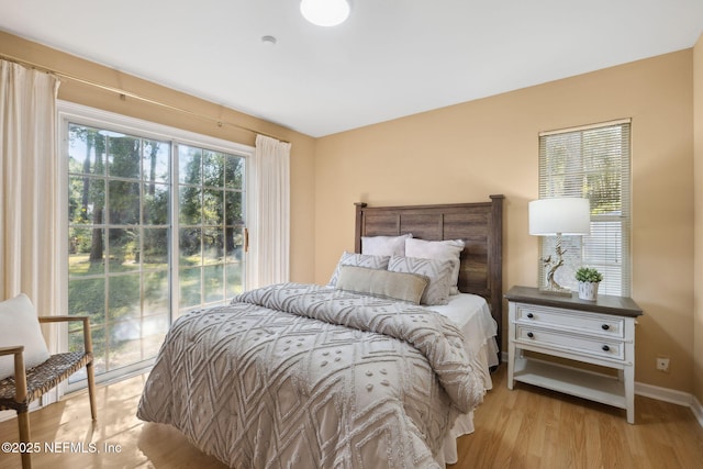 bedroom with access to exterior and light hardwood / wood-style flooring