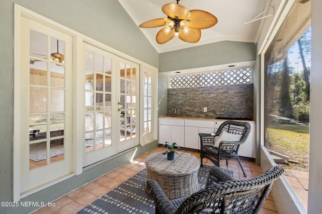 sunroom featuring vaulted ceiling, sink, and ceiling fan