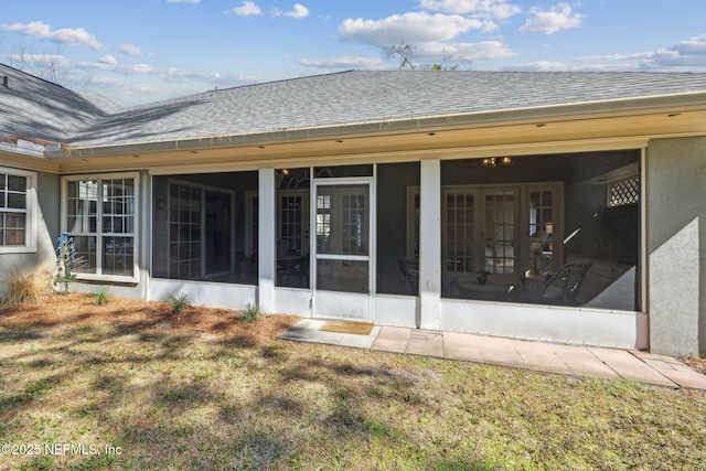 rear view of property featuring a sunroom and a lawn