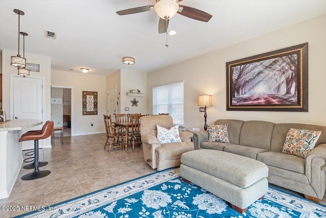 living room with ceiling fan, sink, and light tile patterned floors