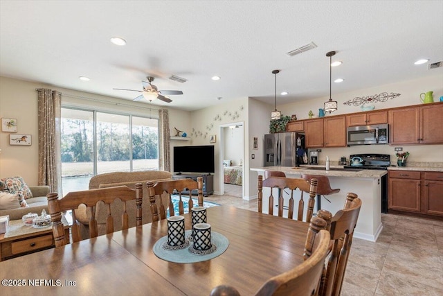 tiled dining space with ceiling fan