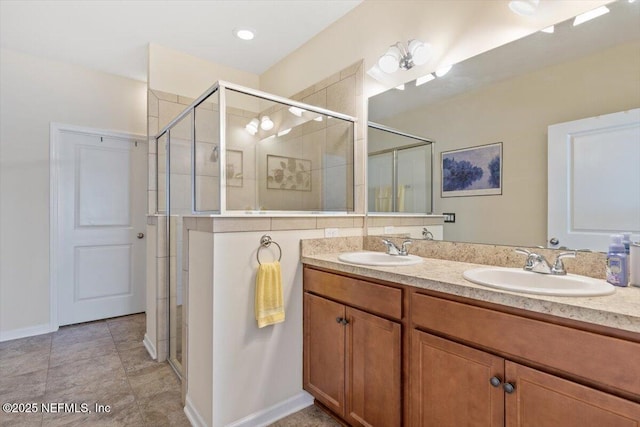 bathroom with a shower with door, vanity, and tile patterned flooring