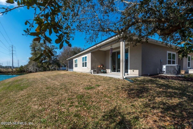 back of house featuring central AC unit, a lawn, and a patio area