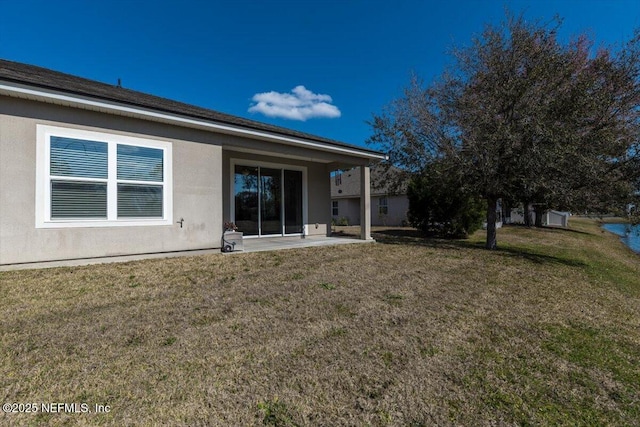 rear view of house with a yard and a patio