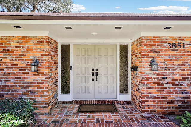 view of exterior entry with brick siding