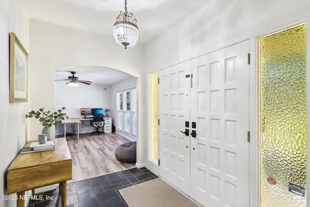 foyer entrance with arched walkways and stone finish flooring