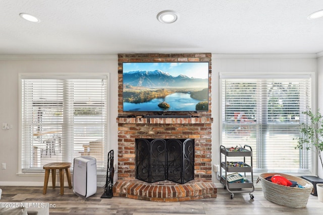 living room with a textured ceiling, wood finished floors, and crown molding