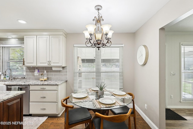 dining area featuring baseboards, a chandelier, and dark wood-type flooring