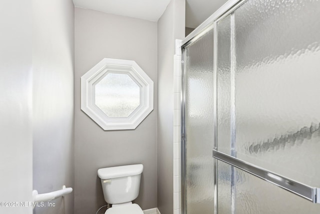 bathroom with a stall shower and toilet