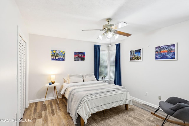 bedroom featuring ceiling fan, light wood-type flooring, and baseboards