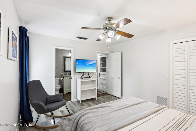 bedroom featuring visible vents, ceiling fan, ensuite bath, and wood finished floors