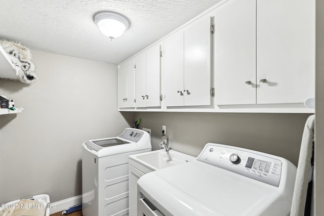 washroom featuring cabinet space, independent washer and dryer, a textured ceiling, and baseboards