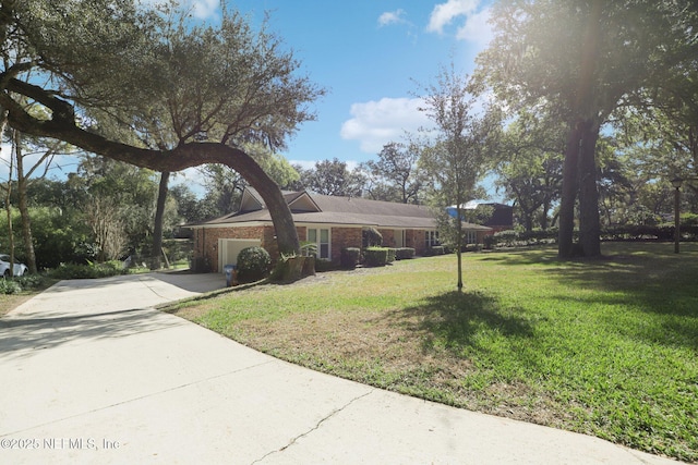 view of front of house featuring driveway, a garage, a front lawn, and brick siding