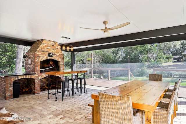 view of patio / terrace with ceiling fan, an outdoor brick fireplace, outdoor dining area, and fence