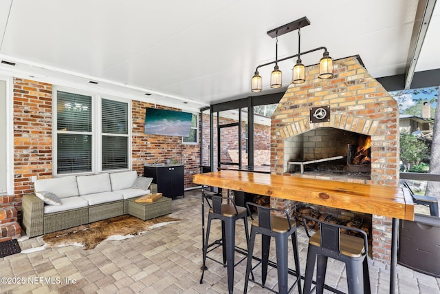 view of patio with outdoor dry bar and an outdoor living space with a fireplace