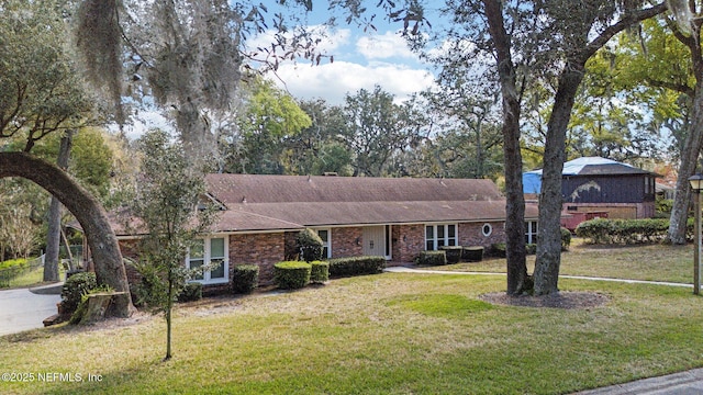 ranch-style house with a front lawn and brick siding