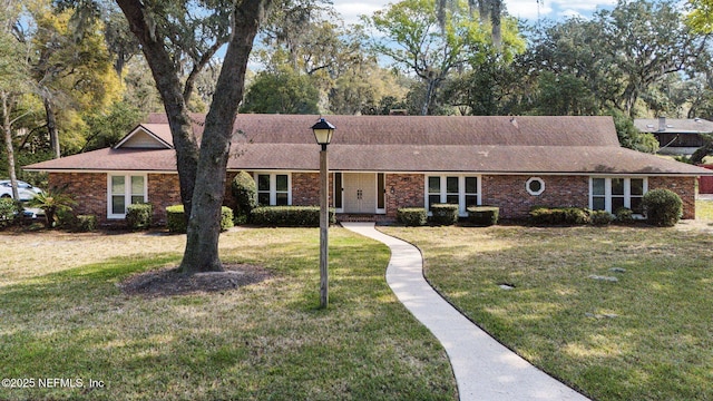 ranch-style house with a front yard and brick siding