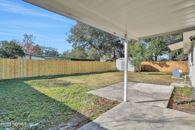 view of yard featuring cooling unit, a shed, and a patio area