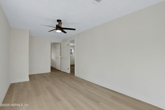 empty room with ceiling fan and light hardwood / wood-style floors