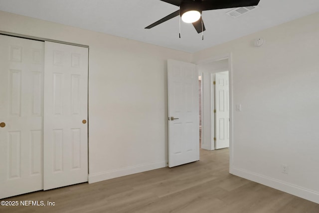 unfurnished bedroom featuring light hardwood / wood-style floors, a closet, and ceiling fan