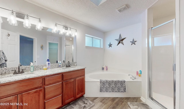 bathroom featuring vanity, hardwood / wood-style floors, independent shower and bath, and a textured ceiling