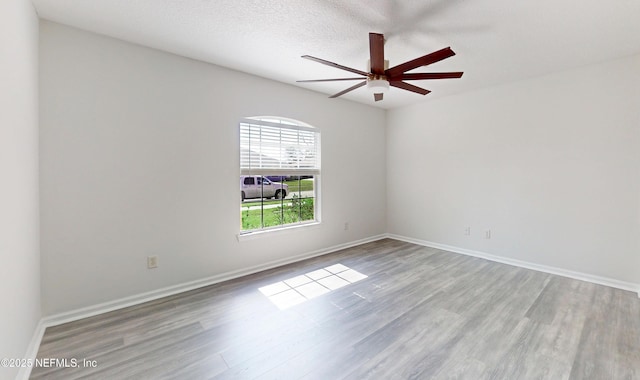 spare room featuring ceiling fan, a textured ceiling, and light wood-type flooring