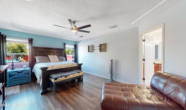 bedroom with dark wood-type flooring, connected bathroom, a textured ceiling, and ceiling fan