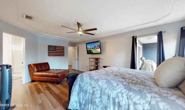 bedroom featuring ceiling fan, a textured ceiling, and light wood-type flooring